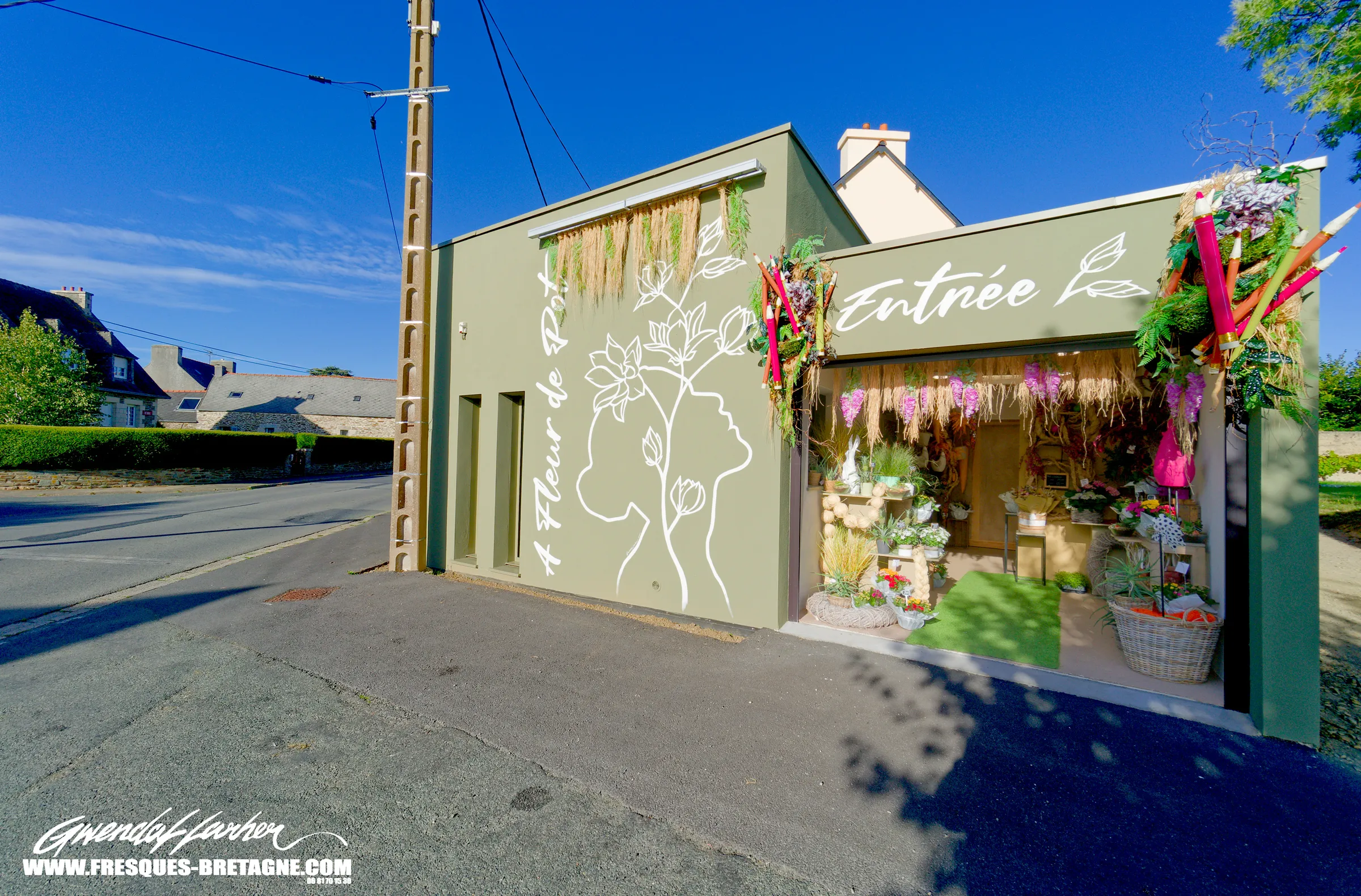 Enseigne artistique peinte sur la façade d'un fleuriste à Plestin-les-Grèves, réalisée par Gwendal Larher.
